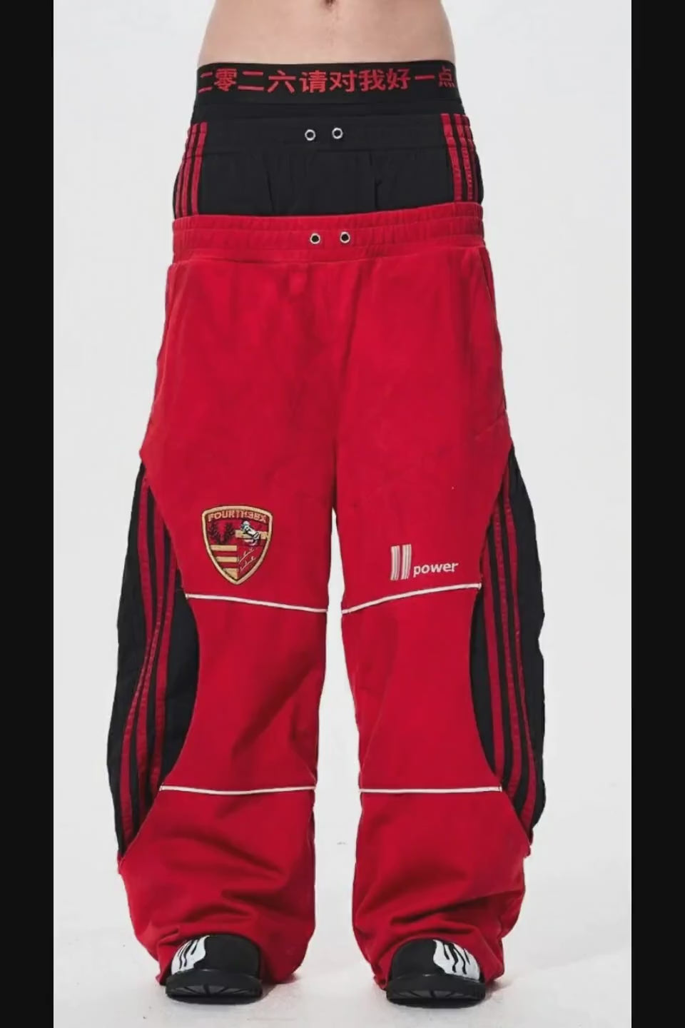 Red Stripe Sweatpants。サイドの太いレッドラインと、裾にボリュームが溜まるワイドなシルエットの質感